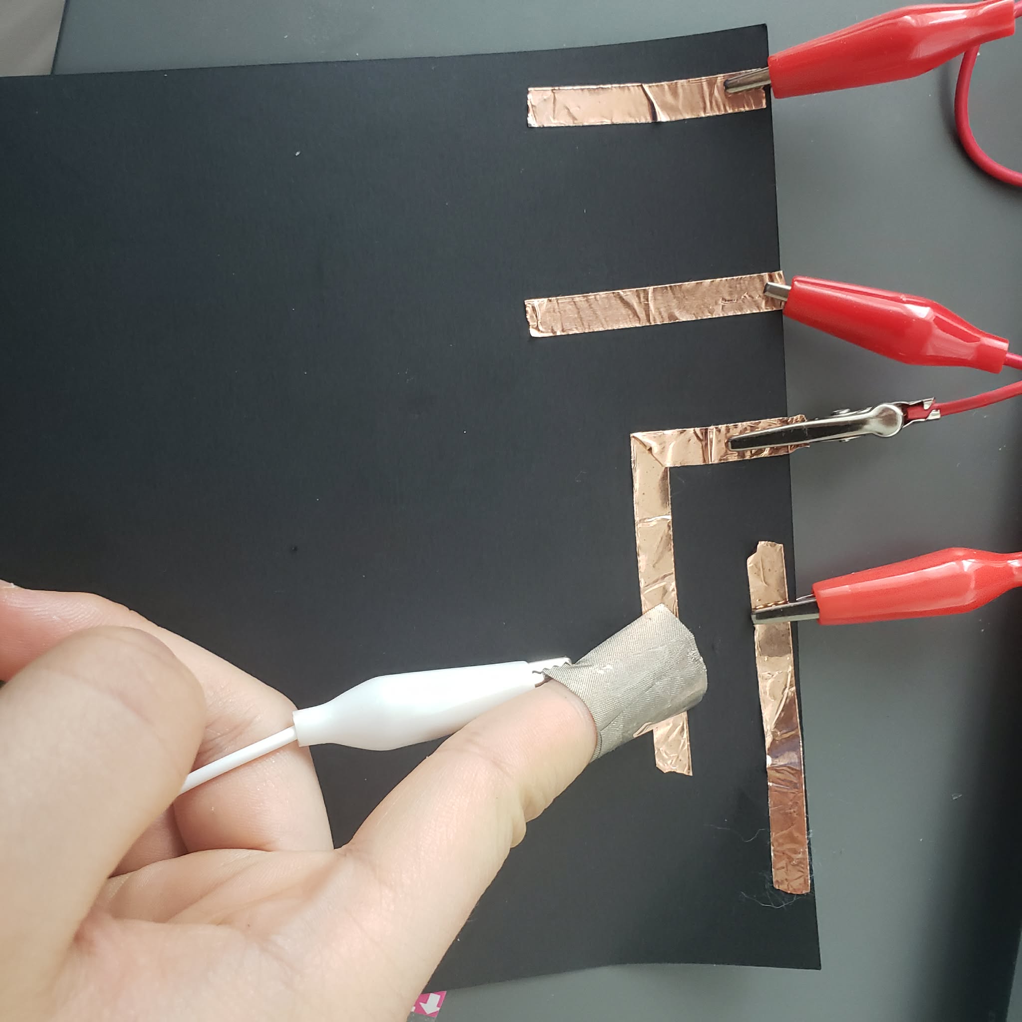 I connect the interaction by wrapping a piece of conductive cloth on my finger and touch the copper tape.