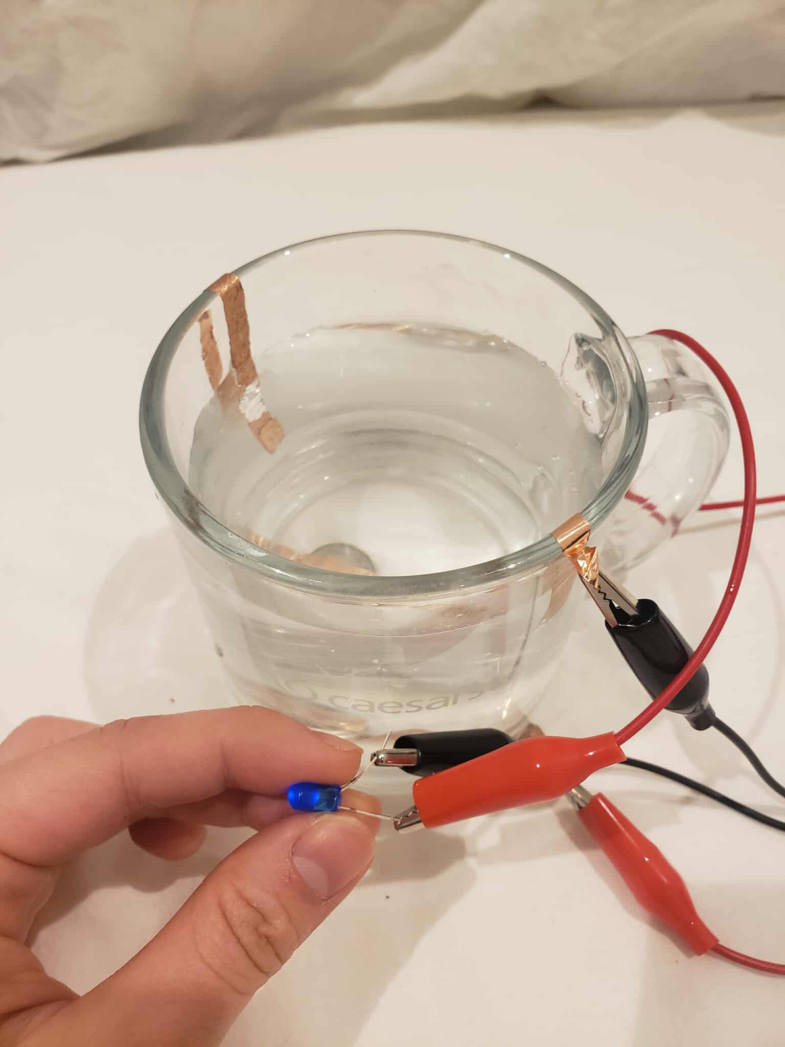 The glass cup with its circuit turned on when water is filled to a certain threshold. The water conducts electricity and connect it to the rest of the circuit. The electricity is very faint for this one.